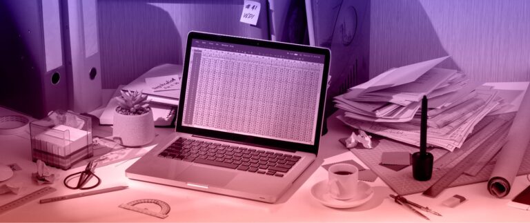 A laptop on a desk surrounded by papers and items, related to "The Cost of Bad Data in the Nonprofit Sector."